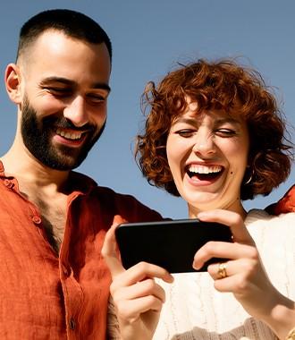 Two people smiling at a phone
