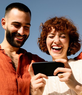 Two people smiling at a phone